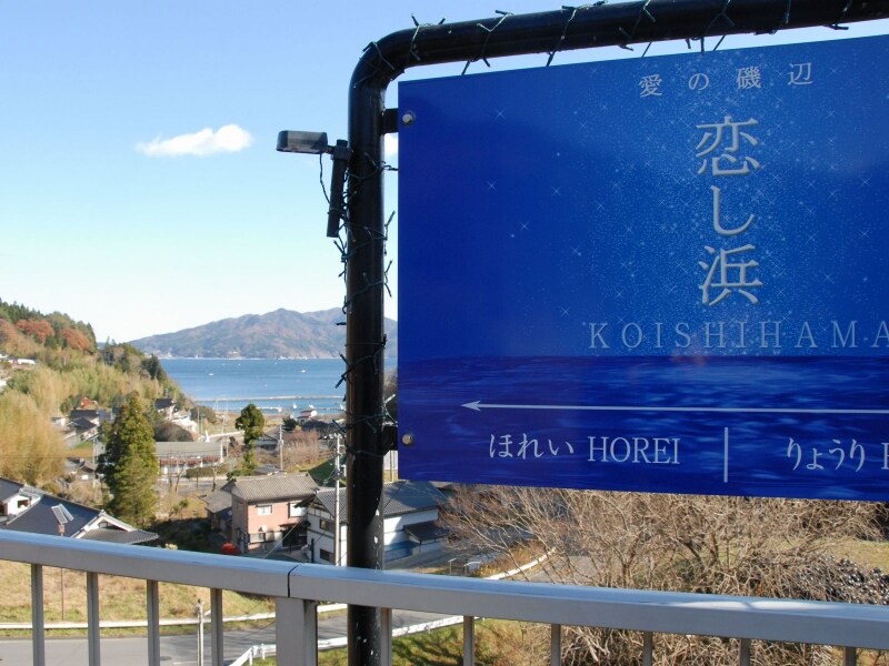「恋し浜」の駅名標と海