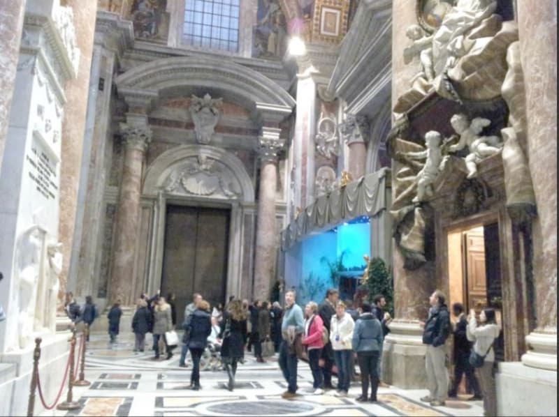 左の側廊を出口に向かって見たところ。右にクーポラから降りてきた人のための出口、その先は洗礼礼拝堂、突き当りは死の扉、左側にカノーヴァ作スチュアート家のモニュメントが見えています