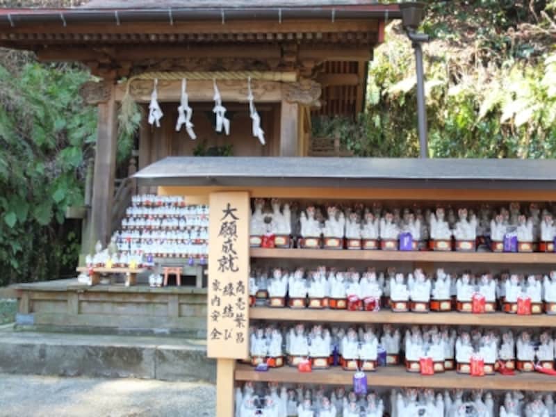 本殿と奉納された白い陶器製のキツネ
