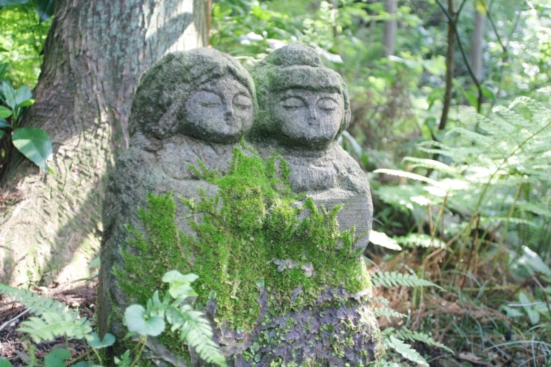 大きな石の下にたたずむ石仏