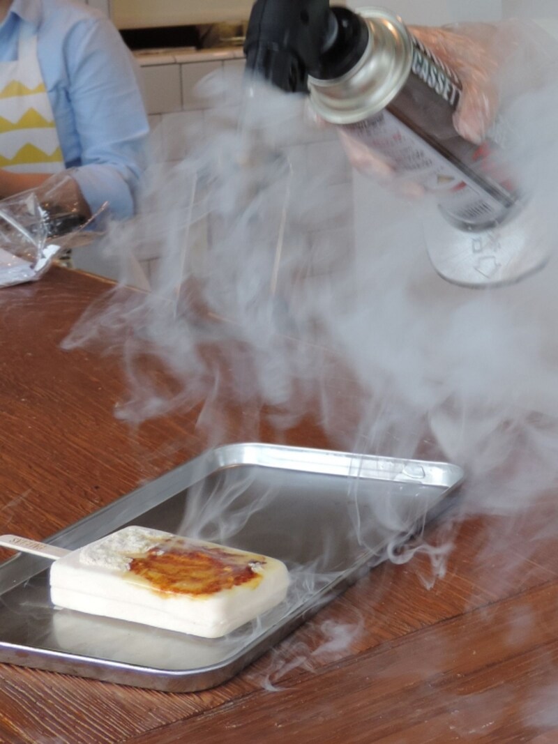 「PALETAS」の「りんごブリュレ」の製造工程。フローズン・フルーツバーの上に和三盆糖ときび糖をのせ、焼き目をつける