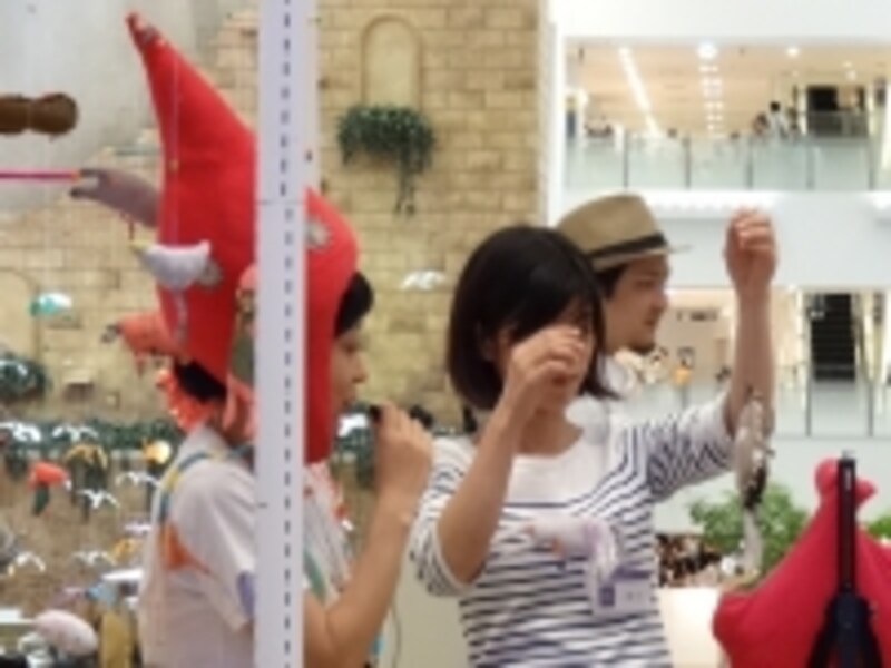 説明するスサイさん（左）と作品例