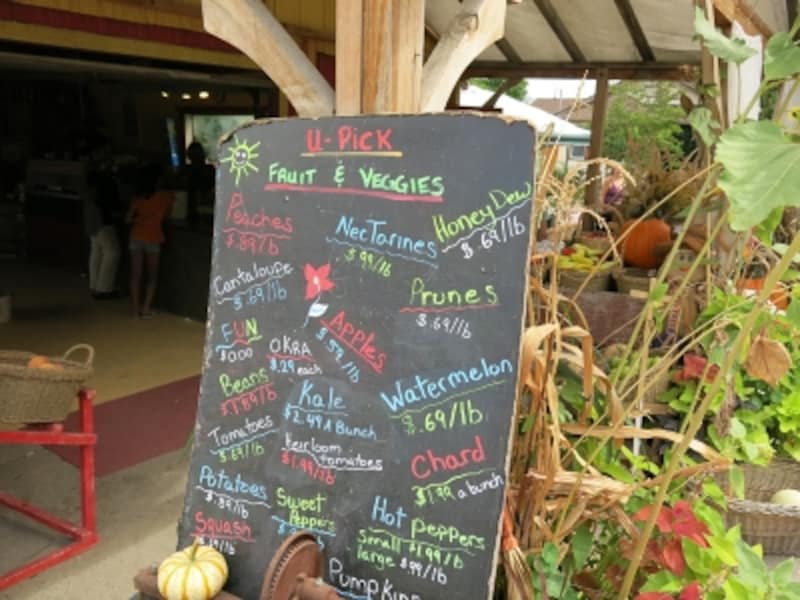 U Pickと呼ばれる果物狩り。その日採れる果物や野菜の種類と、重さによる料金が表示されている看板