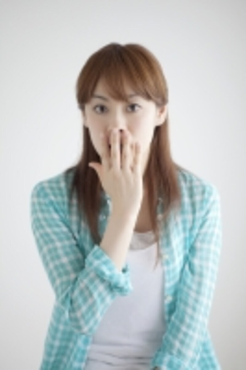 口元に手をやる女性
