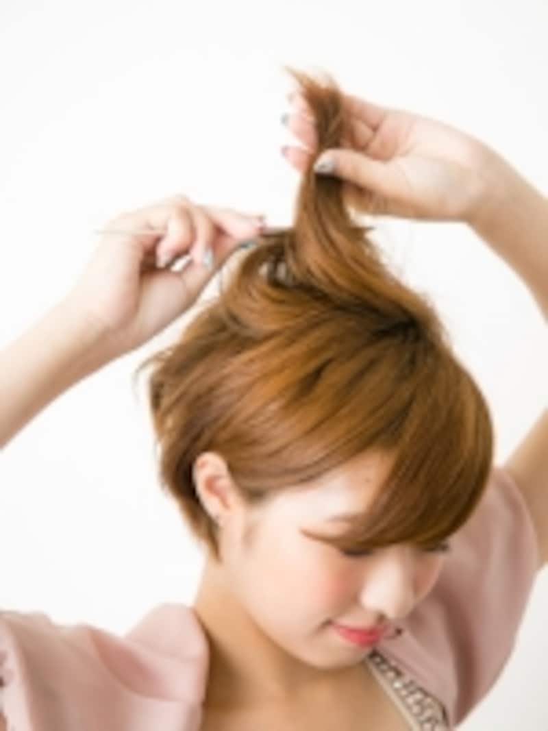 巻いた髪の根元で逆毛を立てる
