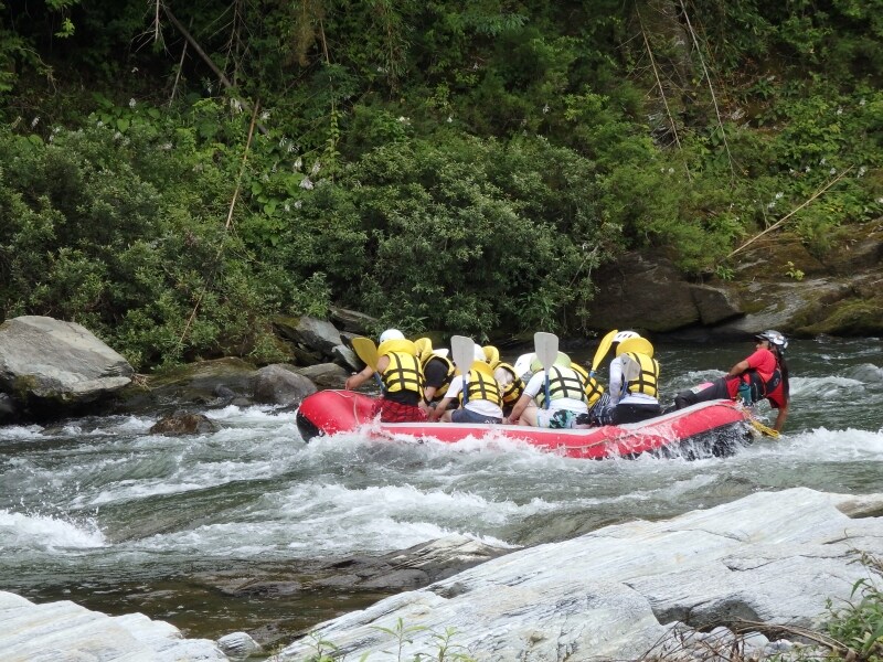 水しぶきをあげて急流を下るラフティングのボート