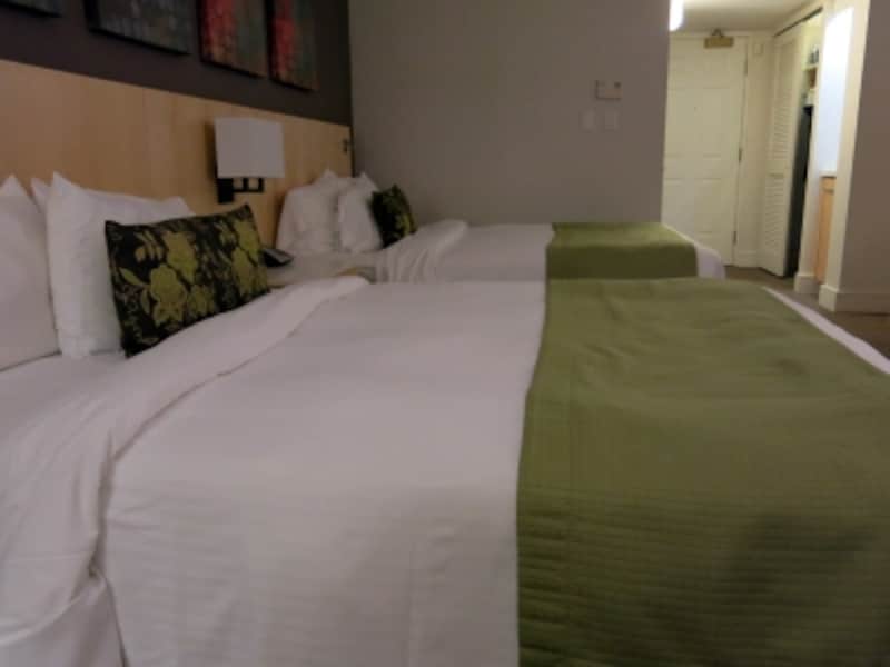 淡いグリーンのベッドカバーが落ち着いた空間を演出