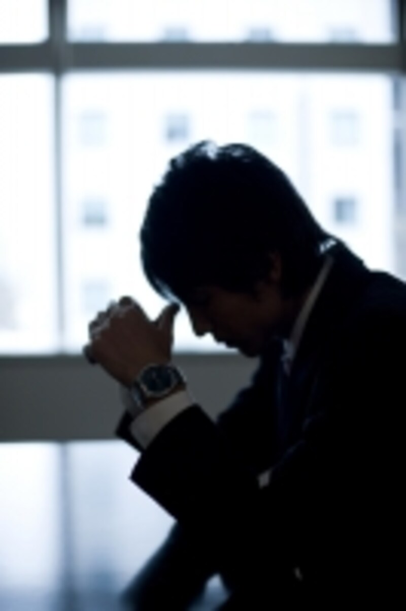 暗くうつむく男性