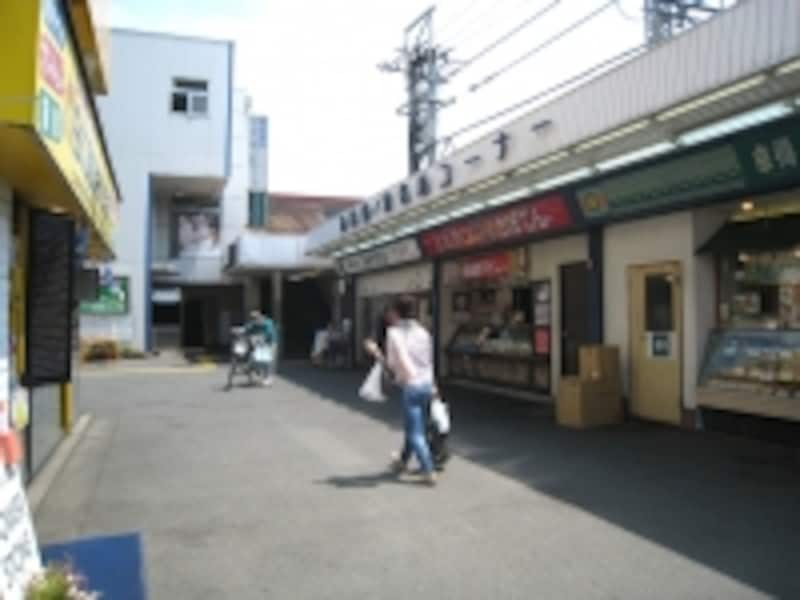 西武新宿線鷺ノ宮駅の、商店街のある南口駅前。店舗の先に駅への入り口があり、その奥は駐輪場