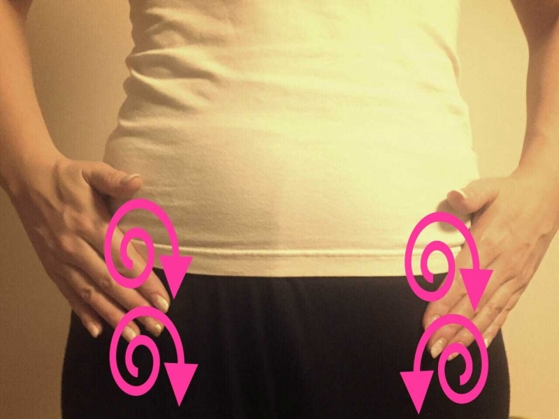 腰骨の上を押し回す