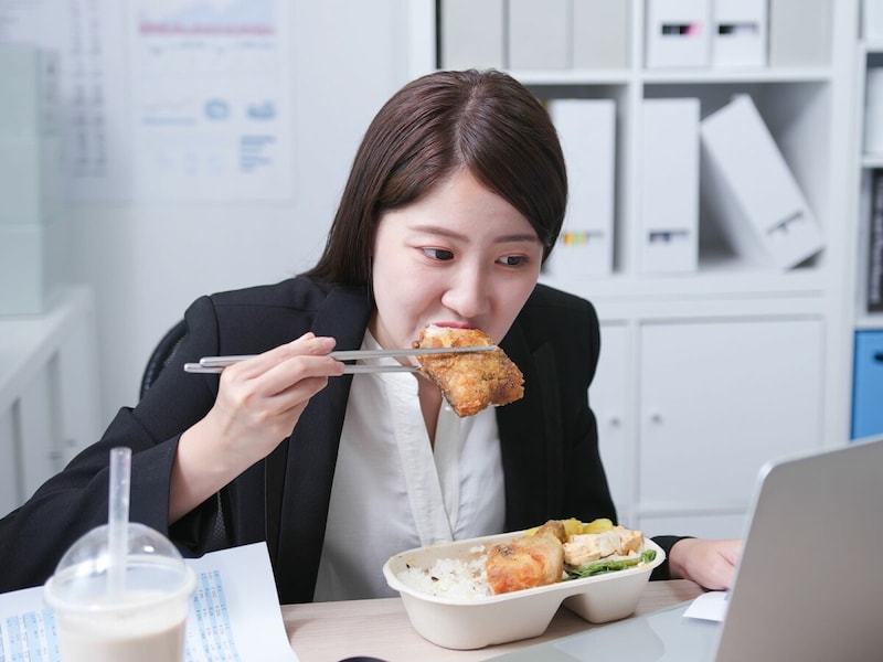 仕事中に食事をする忙しい女性
