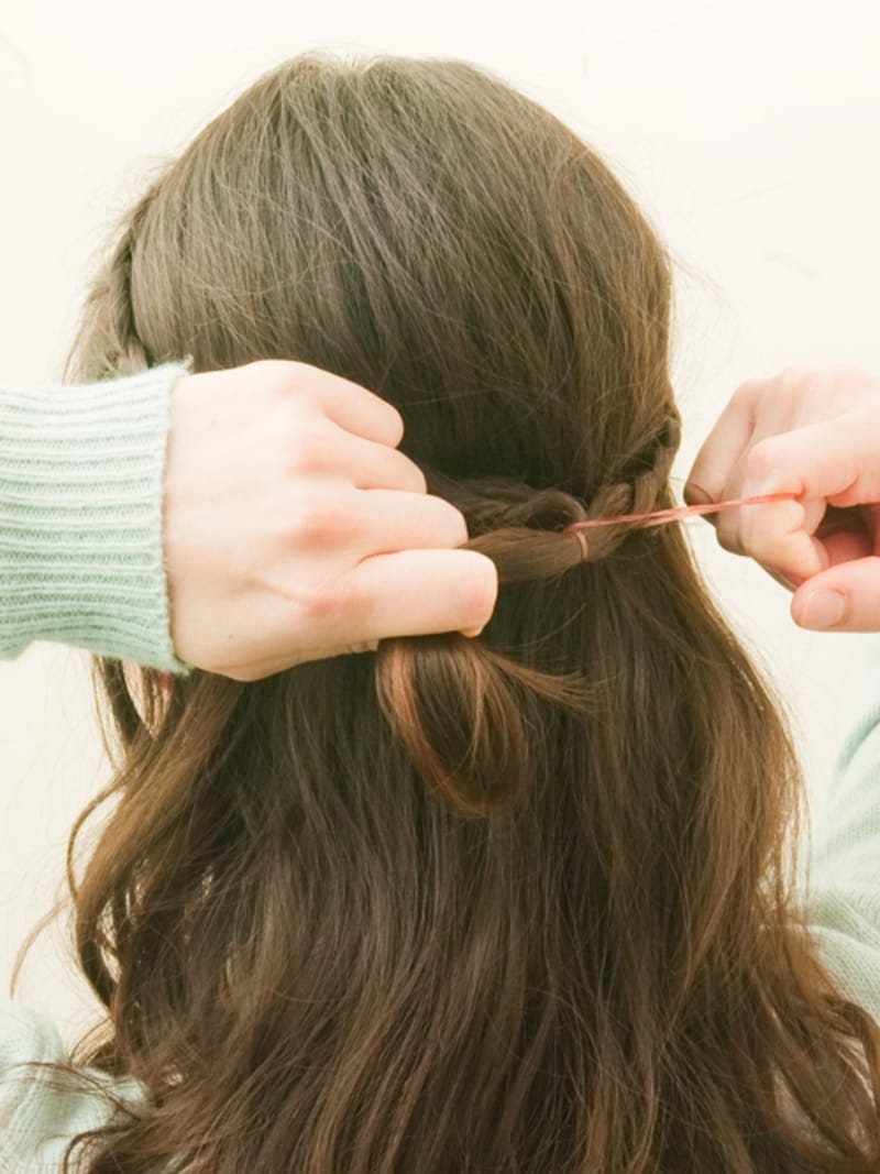 合わせたみつあみをゴムでとめる