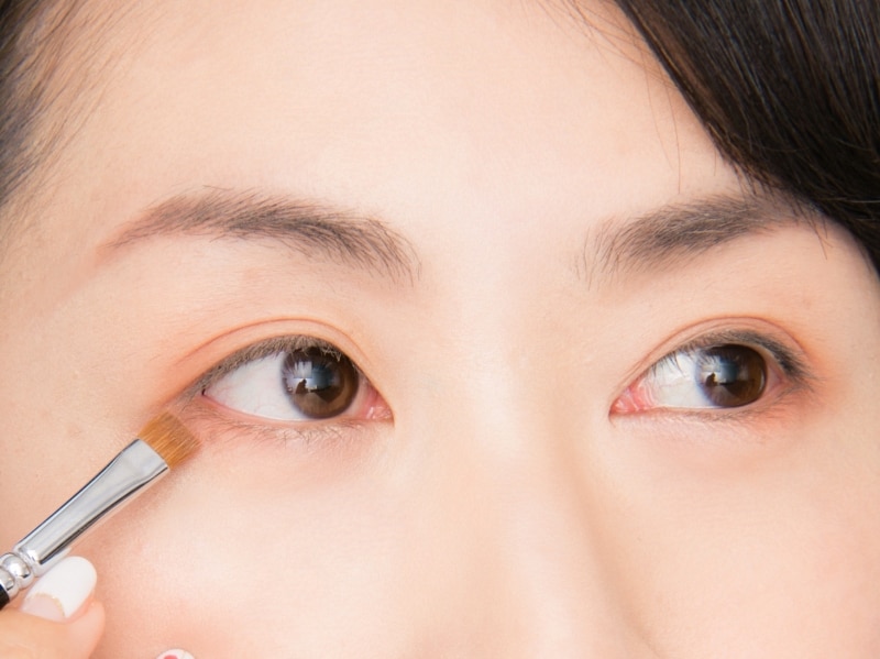 まつげの生え際にブラシを置いて外側にはらう