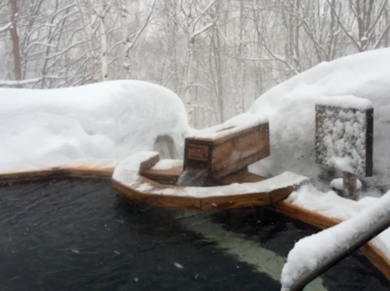 子どもたちは、お風呂のまわりにある雪で温泉に入りながら雪だるま作り