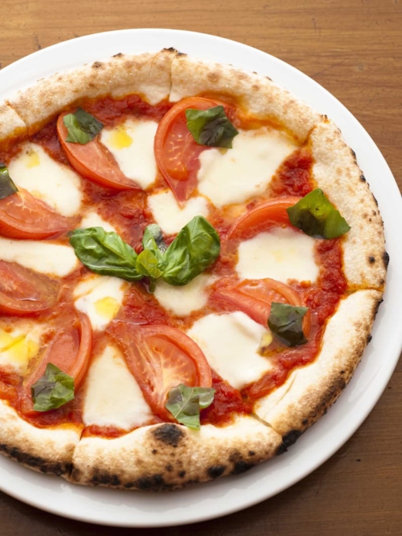 トマトと水牛モッツァレラチーズのピザ（レギュラー1200円、ハーフ700円）。専用のピザ窯で焼き上げてあり、モチモチ食感がたまらない！