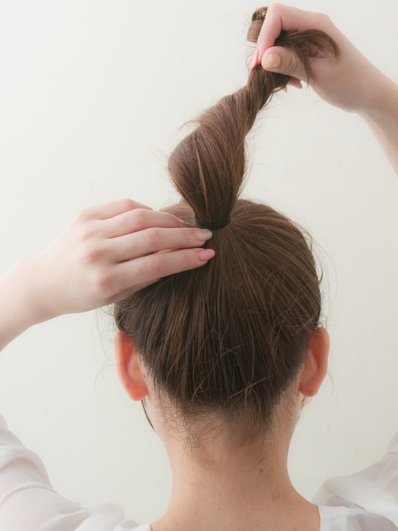 ポニーテールの毛先をねじる