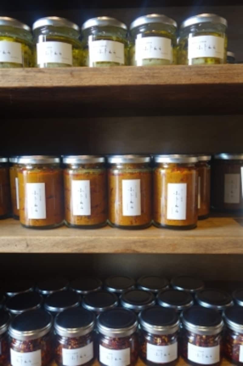 手作りの瓶詰めたち。生姜たっぷりの「カレーのもと」は北海道出身の藤原さん思い出の味。とびきり美味しいパクチーが手に入ったことでできた「香菜レモンオイル」。「おいしい唐辛子」は小さな子供のいる家庭のテーブルでちょい足しできるので、大人用に便利！