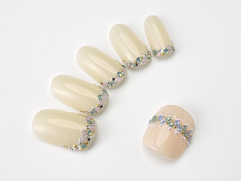 指先にキラキラ輝くグリーンのストーンが華やか