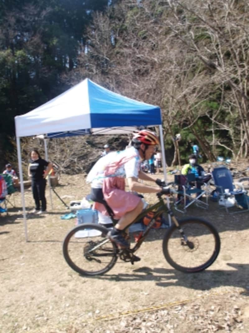 エプロン姿で、マウンテンバイク