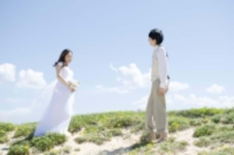 砂浜で式をするカップル