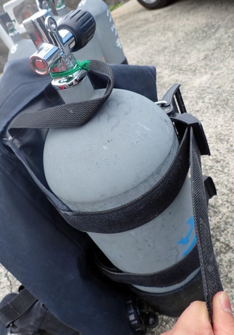 BCDのベルトでタンクをしっかりと留めます。緩いと水中でタンクが外れてしまうことも。BCDの種類によって留め方が異なるので注意しましょう。