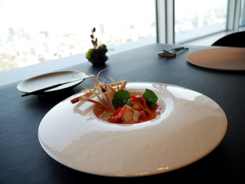 月に見立てたプレートに盛りつけられた魚介料理