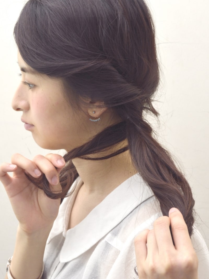 耳前の毛束をツイストしながら結び目に巻きつける