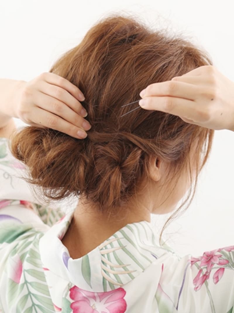 ねじった毛束を中央に集めてピン留め