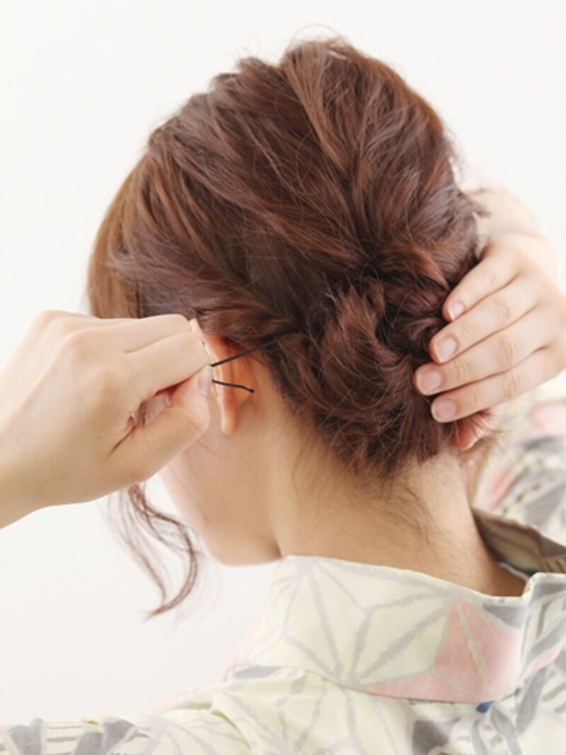 3つの毛束をまとめて毛先を結び目に折り込む