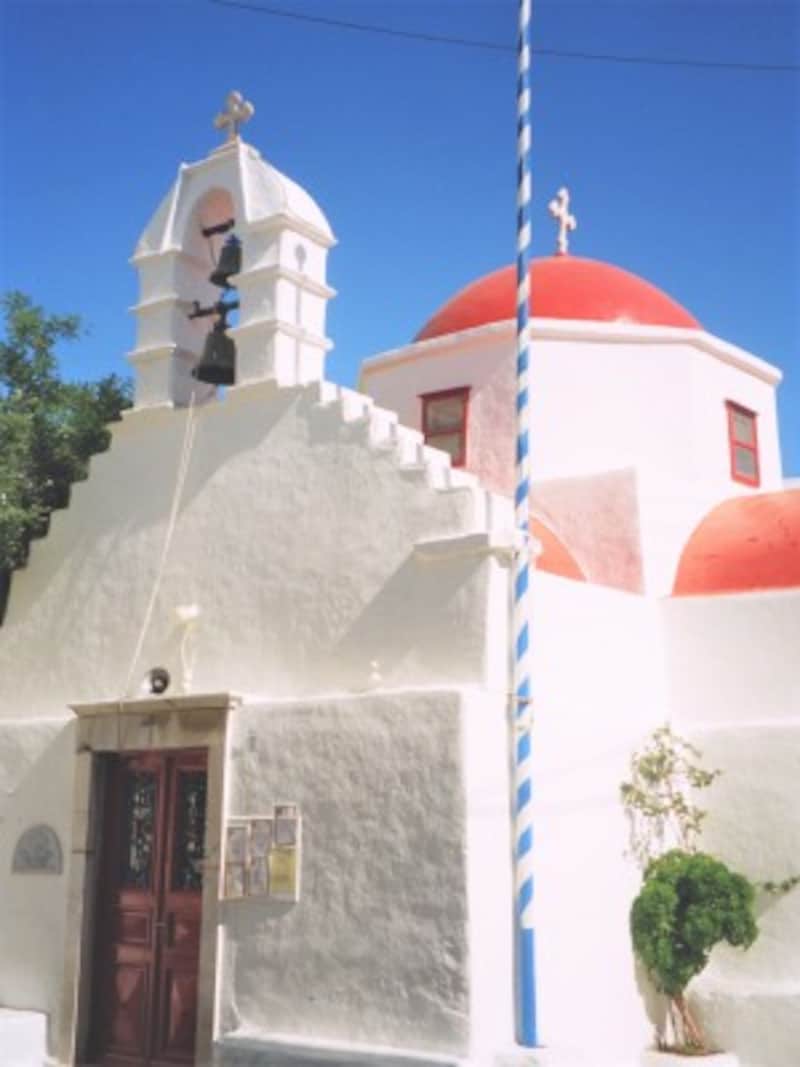 ミコノス島の教会。白壁の街並みが空の青や太陽の赤をいっそう引き立てる