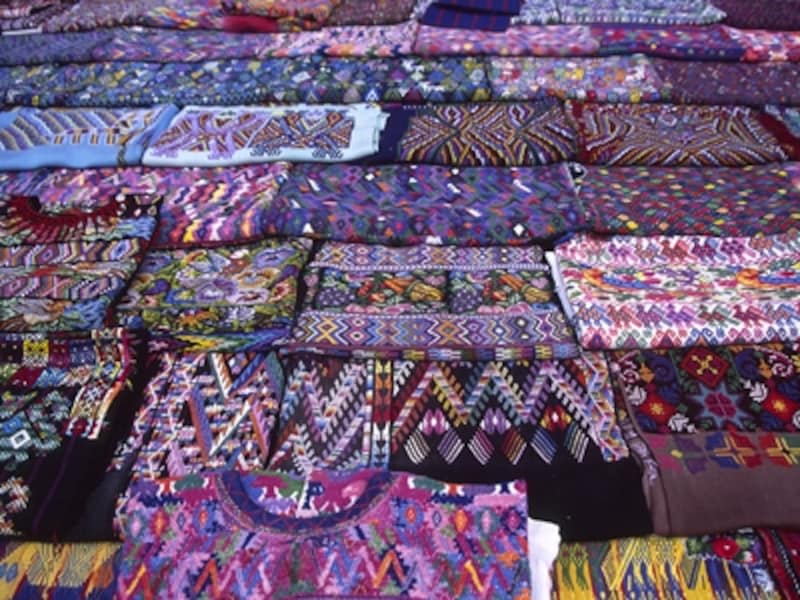 アンティグア周辺の人々は、このような幾何学文様のウイピルを着ていることが多い。露天のウイピル屋にて ©牧哲雄