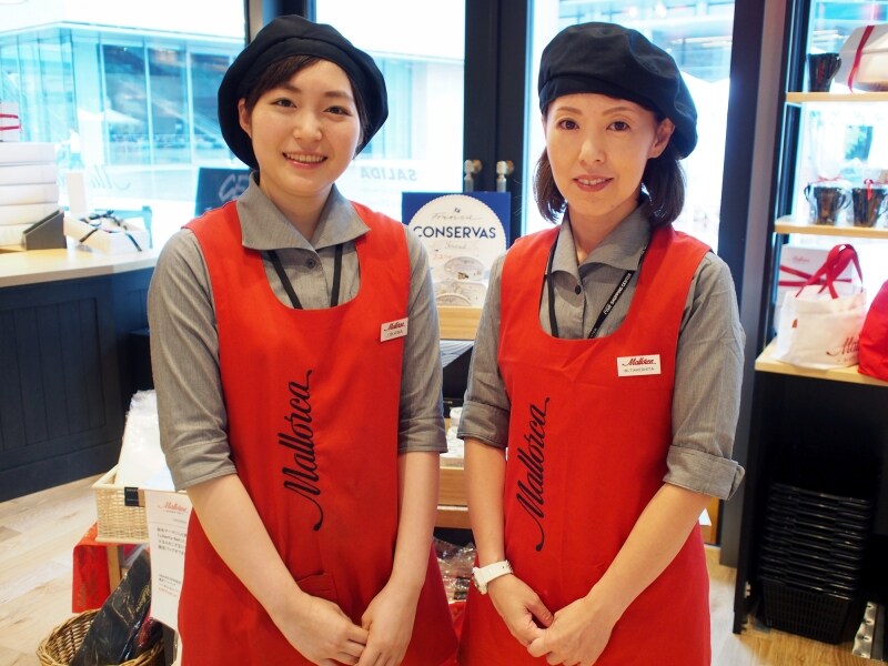 赤いエプロンと黒のベレー帽の可愛らしい制服が印象的