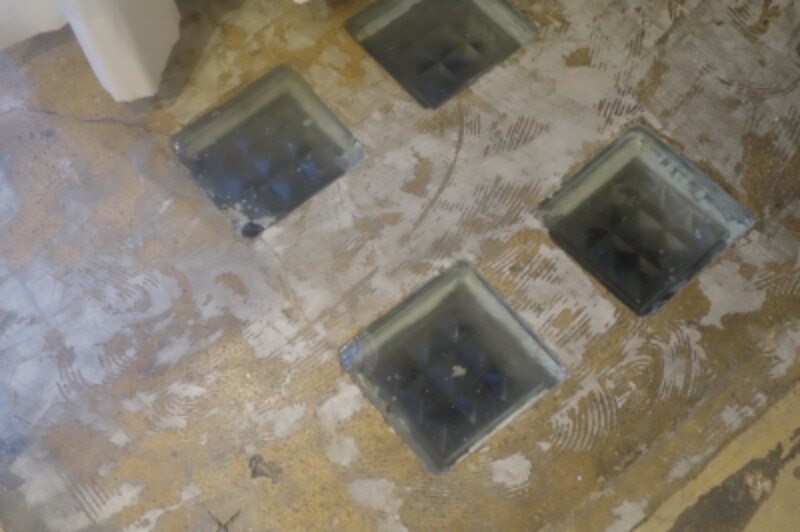 ふと床を見ると地下室への明かり取りが。これは建物に以前からあったもの。ガラスの質感がきれい。
