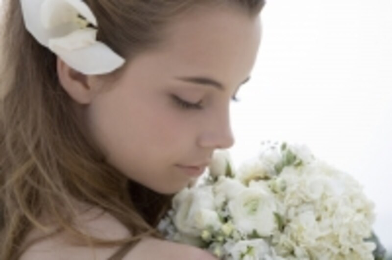 花を頭に乗せて下を向いている女性