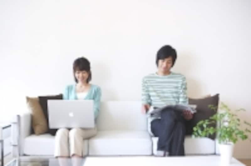 パソコンをしながら離れて座る男女