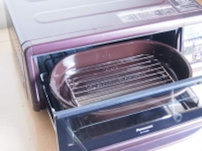 扉をあけて、ホウロウのくんせい容器と網をセッ