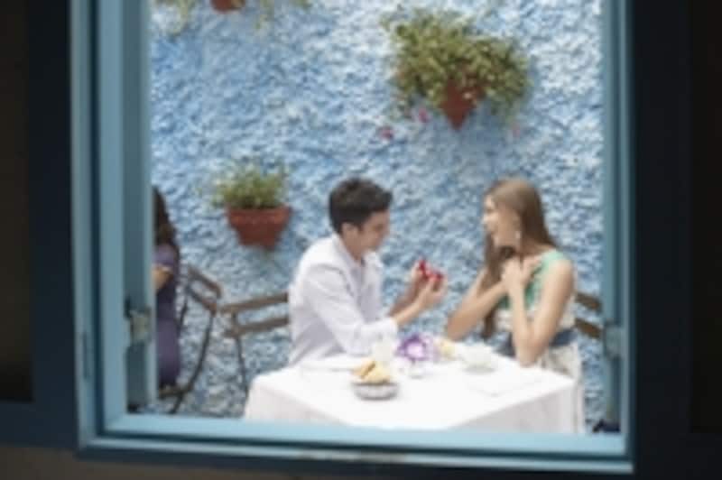 白い椅子とテーブルで食事をしている男女