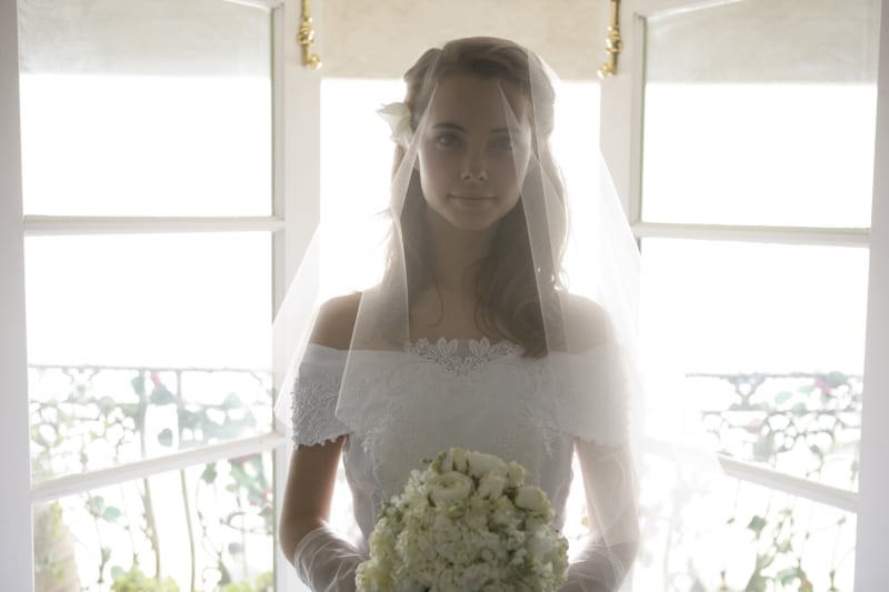 花を持って一人たたずむ女性