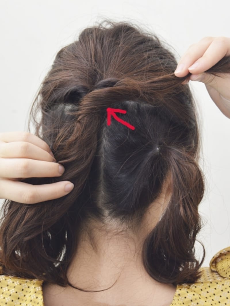 毛束の内側の位置で結び目に向かって押し込むように留めると、アメピンが見えなくなる