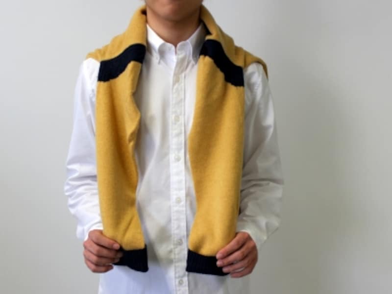 セーターを背中に羽織るようにして、肩から袖を垂らして