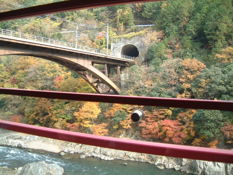 嵯峨野観光鉄道・トロッコ列車の車窓(8)/保津川の紅葉とJR線の鉄橋を望む