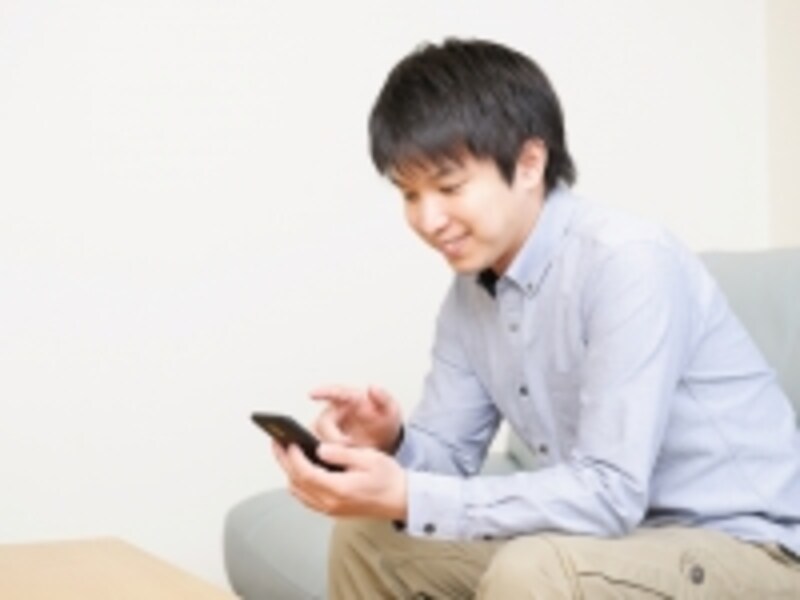 スマホ操作する大学生