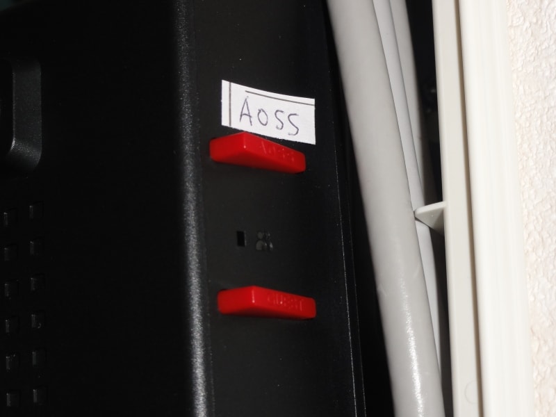上側がAOSSボタン。我が家では、表示が分かりにくいのでシールを貼ってある。