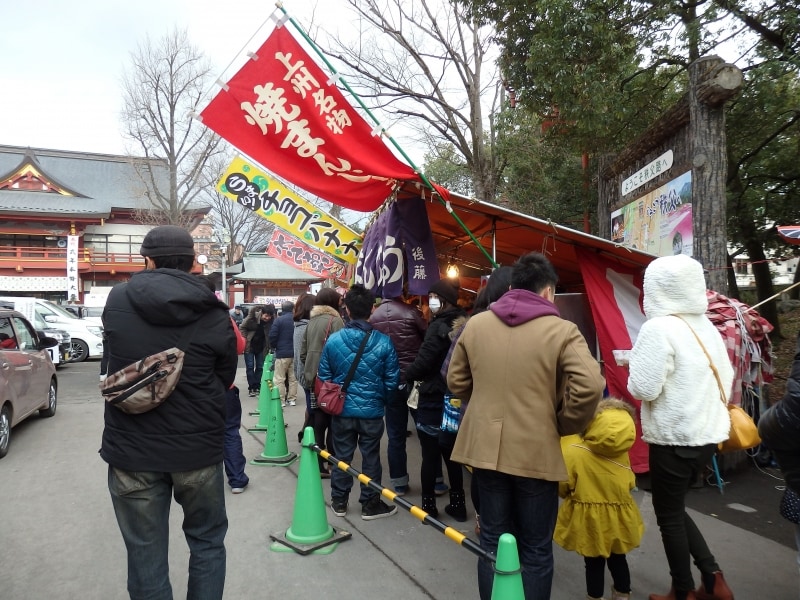 下境内を囲む露店をかすめる初詣客の行列