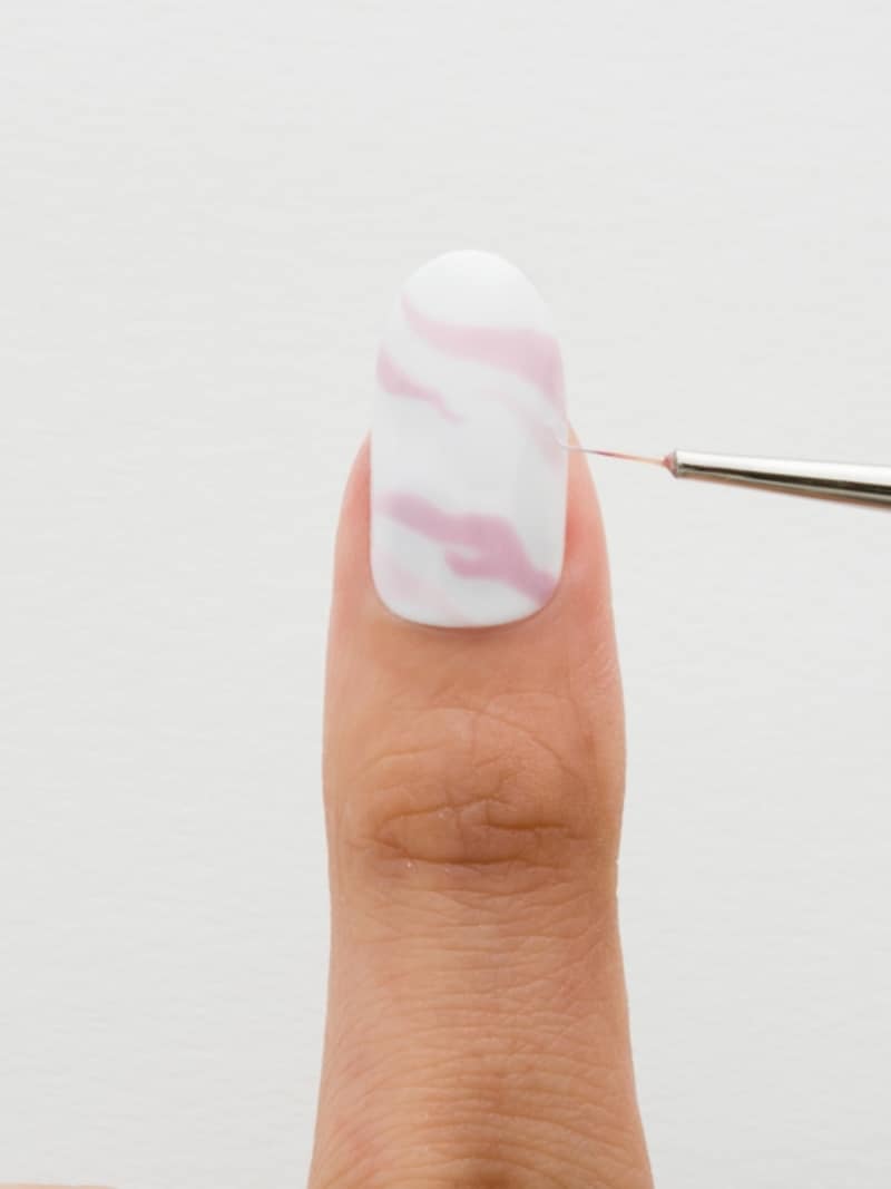 細筆で淡いピンクのラインを引く