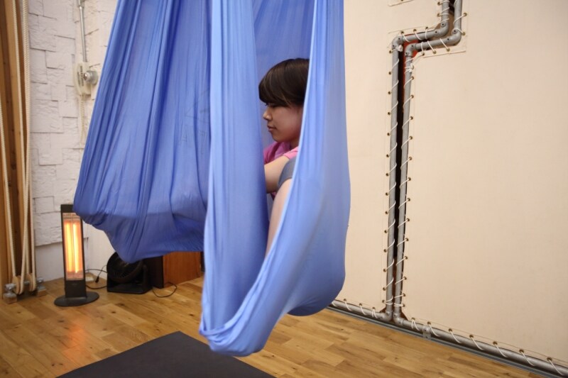 布をまたぎ、つま先まで布を伸ばして中に座るようなポーズをとります