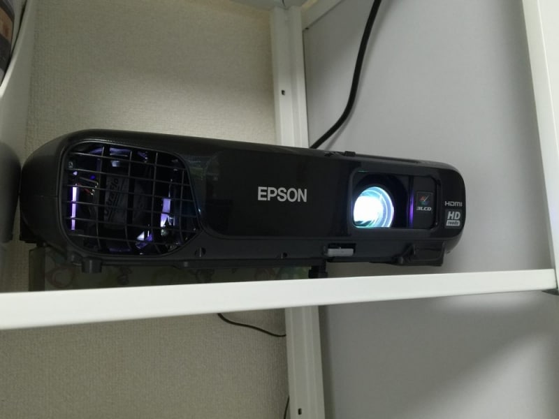 プロジェクターは、壁の反対側の棚や家具の上に設置すれば手軽。専用の金具を使えば天井から吊り下げることも。