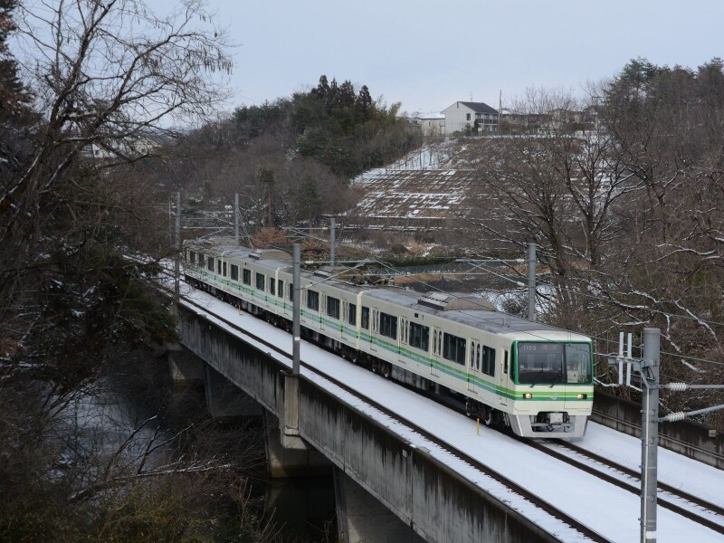 黒松駅付近のため池を渡る電車
