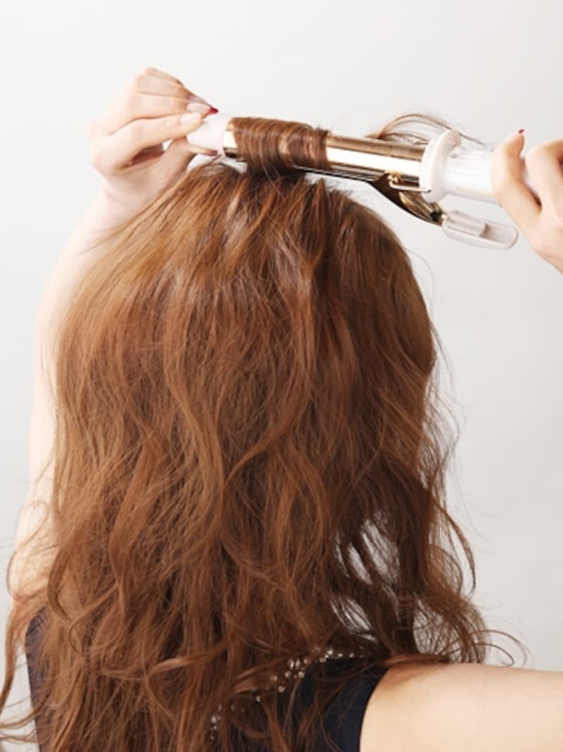 細ロットで髪を根元から中間まで巻いていく
