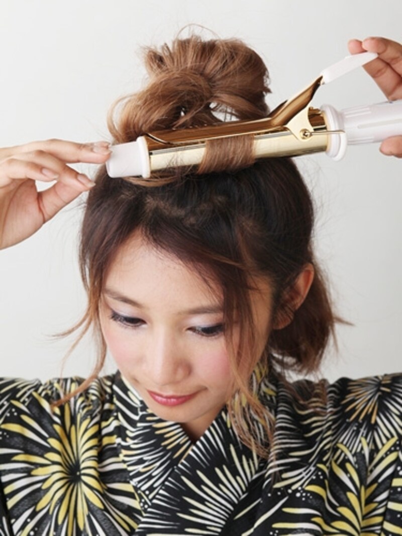 毛束の先にコテを当て、外巻きにクセを付ける